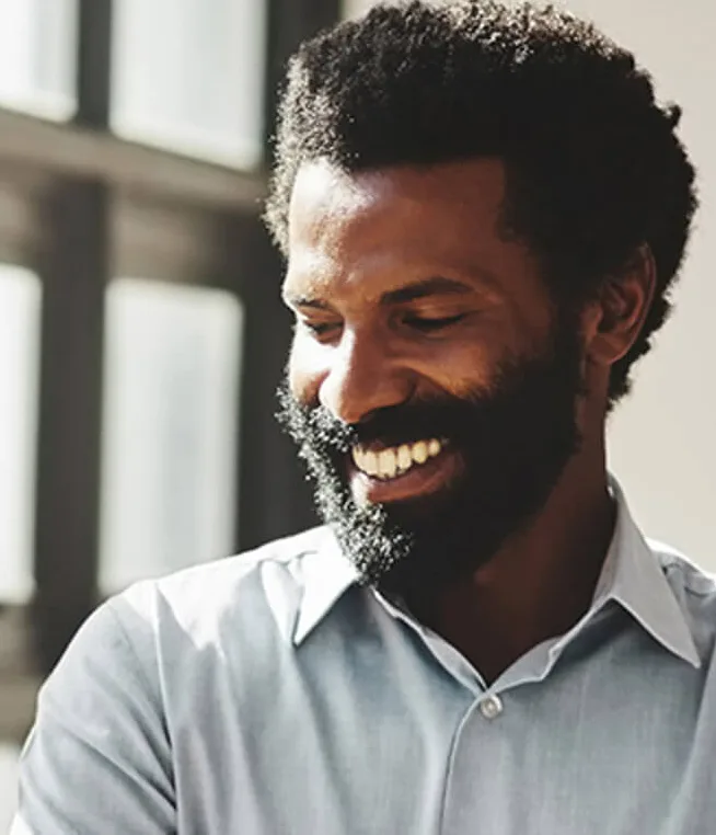 Man smiling next to window