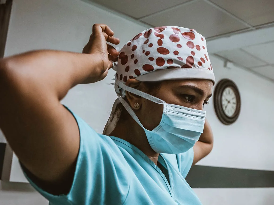 Doctor putting on surgical mask