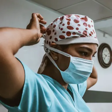 Doctor putting on surgical mask