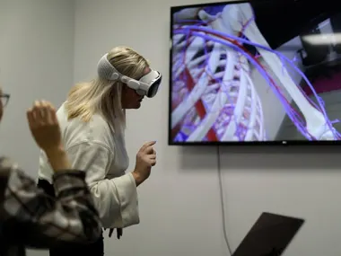 Elsevier's Global Medical Education team works on Complete HeartX, designed for Apple Vision Pro. The woman closest to the screen is wearing an Apple Vision pro headset.