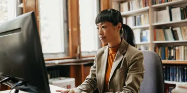 Librarian sitting in office working on laptop