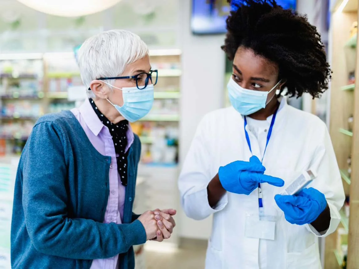 Female pharmacist talking to customer