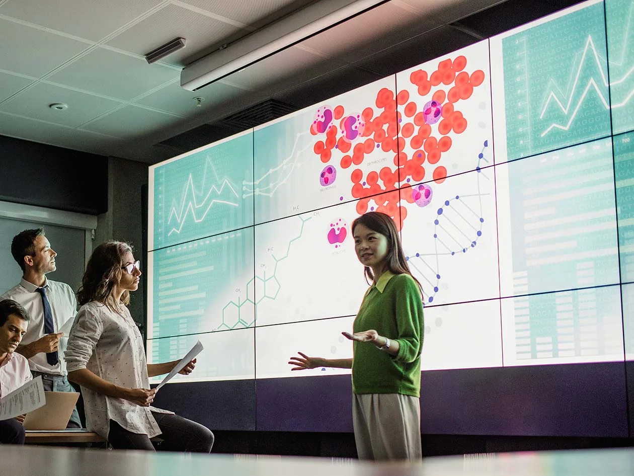 Woman presents dashboard display to team